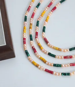 Detailed close-up of natural pearls and colorful cylindrical jade beads on a necklace