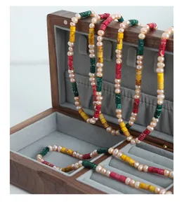 Detail of freshwater pearls and colorful cylindrical gemstones on a luxury jewelry box