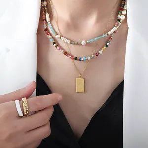 Conjunto de collares de piedras coloridas con colgante dorado y perlas en una modelo