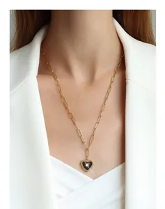 Detail of 18K gold-plated heart pendant with black enamel on a paperclip chain