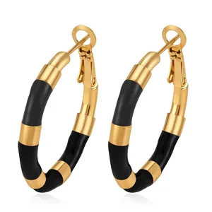 Close-up of black enamel bamboo joint hoop earrings in polished gold stainless steel