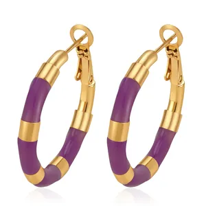 Close-up detail of purple enamel and gold stainless steel bamboo-style hoop earrings.