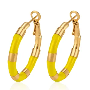 Close-up detail of yellow enamel bamboo joint stainless steel gold hoop earrings for women