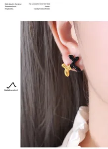 Detail of artistic two-tone balloon dog earring in black and gold titanium steel