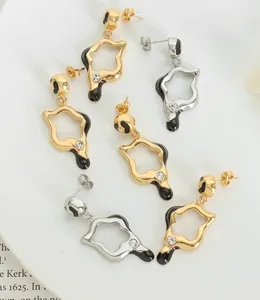 Detalle de pendientes asimétricos esmaltados en oro y plata con pequeños circonios