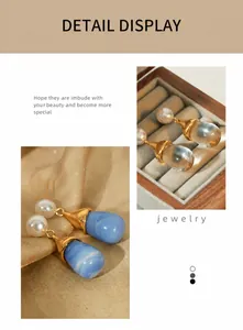 Detail of teardrop pearl and resin earrings in transparent and blue marble finish