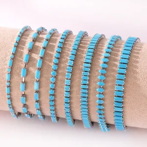 Verschiedene 18k vergoldete Türkis-Armbänder auf einer neutralen Schmuckrolle präsentiert
