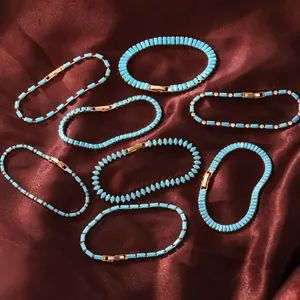 Verschiedene 18k vergoldete Türkis-Armbänder mit Strasssteinen auf Satinhintergrund.