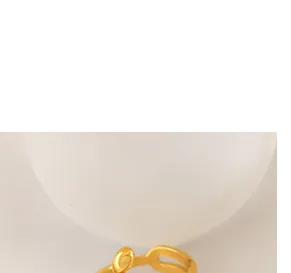 Macro-opname van gouden C-vormige titanium oorbellen met vintage holle kettingtextuur