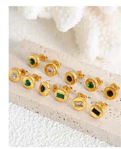 Vue macro de boucles d'oreilles en or 18k avec émeraude et zircon sur base de pierre