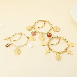 Gros plan détaillé de bracelets religieux vintage avec pendentifs dorés finement gravés.