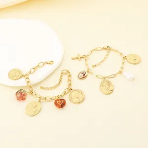 Vue détaillée de deux bracelets vintage en acier inoxydable doré à breloques religieuses