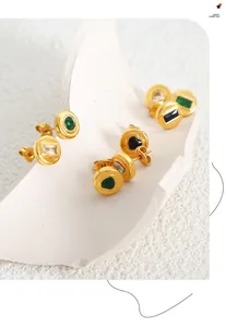 Gros plan de boucles d'oreilles vintage en or 18k avec pierres de zircon vert et noir