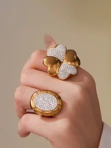 Detailed close-up of 18k gold plated clover and oval rings set with sparkling zircons