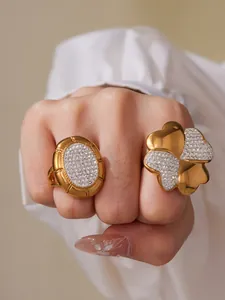 Close-up of gold clover ring with crystal pavé petals and oval rhinestone statement ring