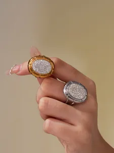 Detailed macro shot of oval gold and silver rings with sparkling pavé crystal settings