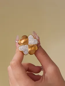 Detailed view of gold plated four-leaf flower open ring with micro-pave crystals