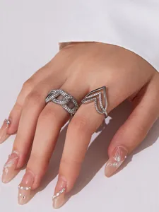 Nahaufnahme glitzernder Herz-Zirkon-Ringe und Kettenband an Modellhand mit feinen Details
