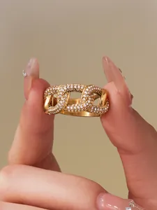 Nahaufnahme eines goldenen Panzerketten-Rings mit Zirkonia-Besatz an der Hand eines Models