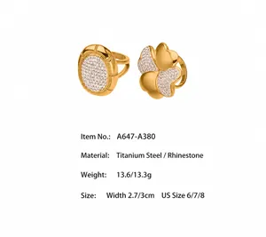Detailed view of gold stainless steel rings with clover shape and pavé crystal settings
