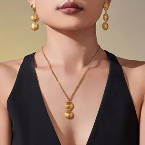 Golden spiral disc jewelry set featuring a necklace and drop earrings on a fashion model