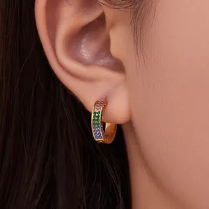 Orecchini a cerchio in oro 18k con zirconi arcobaleno indossati da una modella
