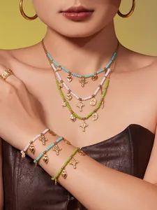Mehrlagiges Goldschmuck-Set mit bunten Perlen, Herzanhängern und diamantbesetztem Kreuz
