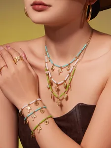 Details des Perlenschmuck-Sets mit türkisfarbenen Akzenten und Goldanhängern