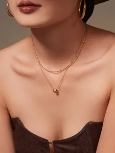Détail du collier double rang plaqué or 18 carats avec chaîne à billes et pendentif sphère