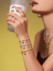 Detail von mehrlagigem Boho-Schmuck mit Kristallsteinen und goldenen Anhängern