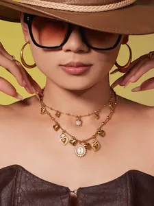 Detail of layered gold necklaces with owl zircon pendants and engraved medallion