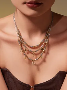 Détail d'un collier à perles superposé avec charms main de Hamsa et étoile en or et argent