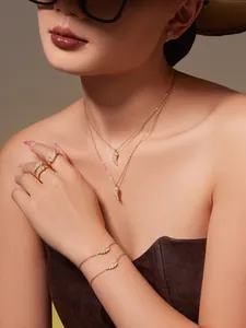 Detailed close-up of 18k gold plated angel wing jewelry set with sparkling zircon stones