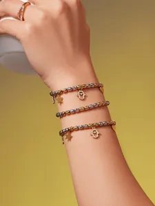 Détail de bracelets perlés dorés avec breloques Main de Fatma et étoile et une bague perle