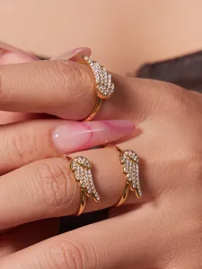 Close-up of three 18k gold plated stainless steel angel wing rings with sparkling zircons