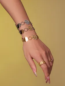 Detailansicht der 18k vergoldeten Armbänder mit Münzanhängern und geprägten Blumenringen