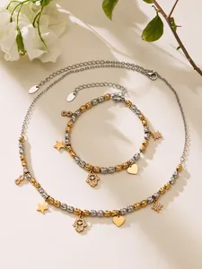 Gros plan d'un ensemble de bijoux bicolores avec breloques étoile, cœur et main hamsa