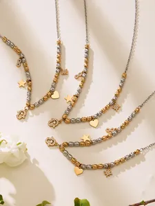 Détail de colliers en perles dorées et argentées avec breloques cœur et étoile en zircon