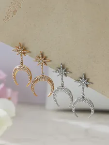 Primo piano di orecchini a luna e stella in oro e argento con pavé di zirconi 5A