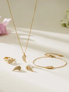 Detailed macro view of 18k gold-plated angel wing jewelry set with sparkling zircon