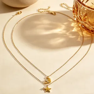 Vista dettagliata di un'elegante collana d'oro a due strati con ciondoli a luna e stella sorridenti