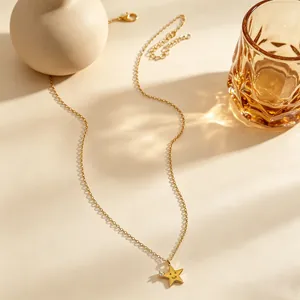 Primo piano della collana a stella dorata con faccina e zircone lucente