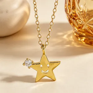Vista dettagliata di una collana a stella dorata con faccina sorridente e zircone.