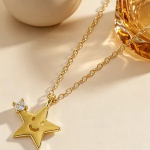 Primo piano di una collana con ciondolo a stella dorata con faccina e piccola pietra zircone
