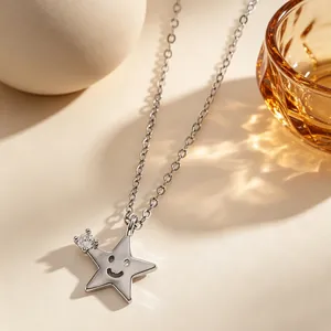 Primo piano di un ciondolo a stella d'argento con faccina e zircone su catenina.