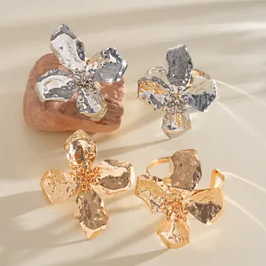 Detailed view of gold and silver metallic wrinkled flower rings and bangles.