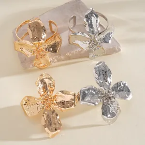 Detailed close-up showing the hammered texture of gold and silver flower bracelets.