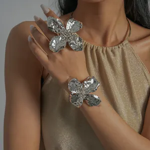 Detail shot of metallic wrinkled flower ring and cuff bracelet set on model.