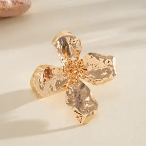 Detailed close-up of a gold metallic wrinkled flower ring featuring hammered petals