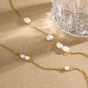 Detailansicht einer eleganten goldenen Edelstahlkette mit Barockperlen bei warmem Licht